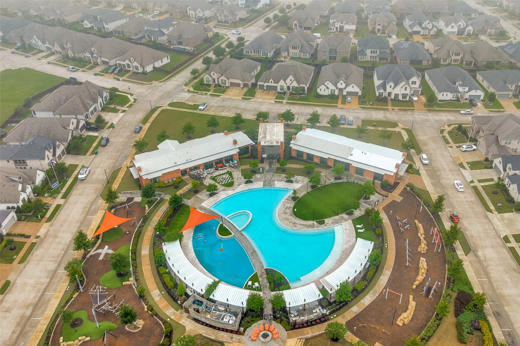 Expansive community amenities featuring a large resort-style pool, surrounding lounge areas, multiple shade structures, and an outdoor recreational area. Take advantage of the indoor space to hose your large celebrations that are better by the pool!