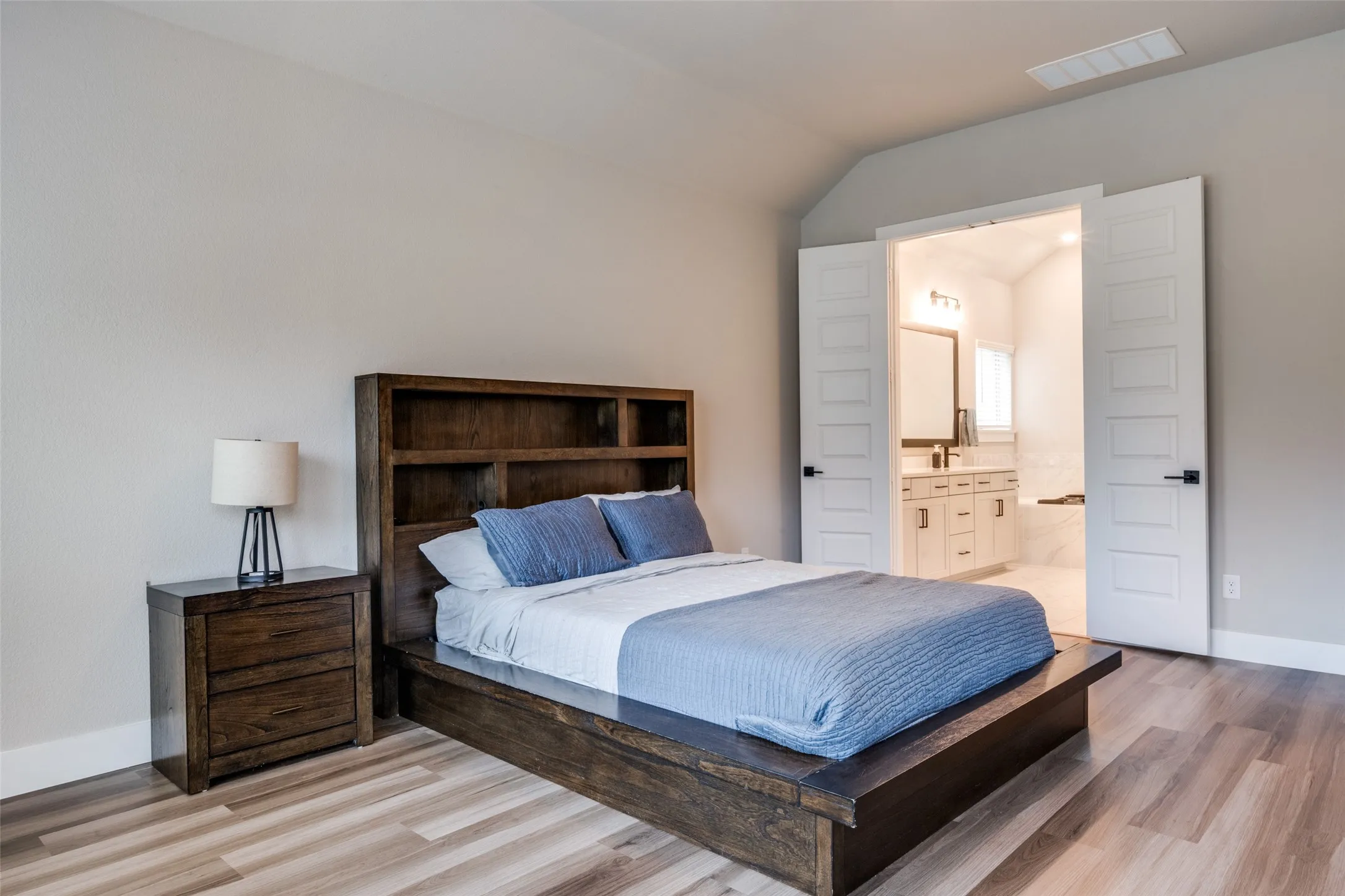 Spacious room has gorgeous LVP flooring and decorative doors providing privacy to the en suite bath.