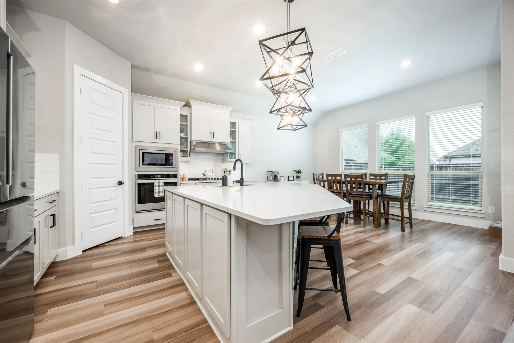 Great modern lighting over the huge island. The white cabinets complement the floors perfectly.