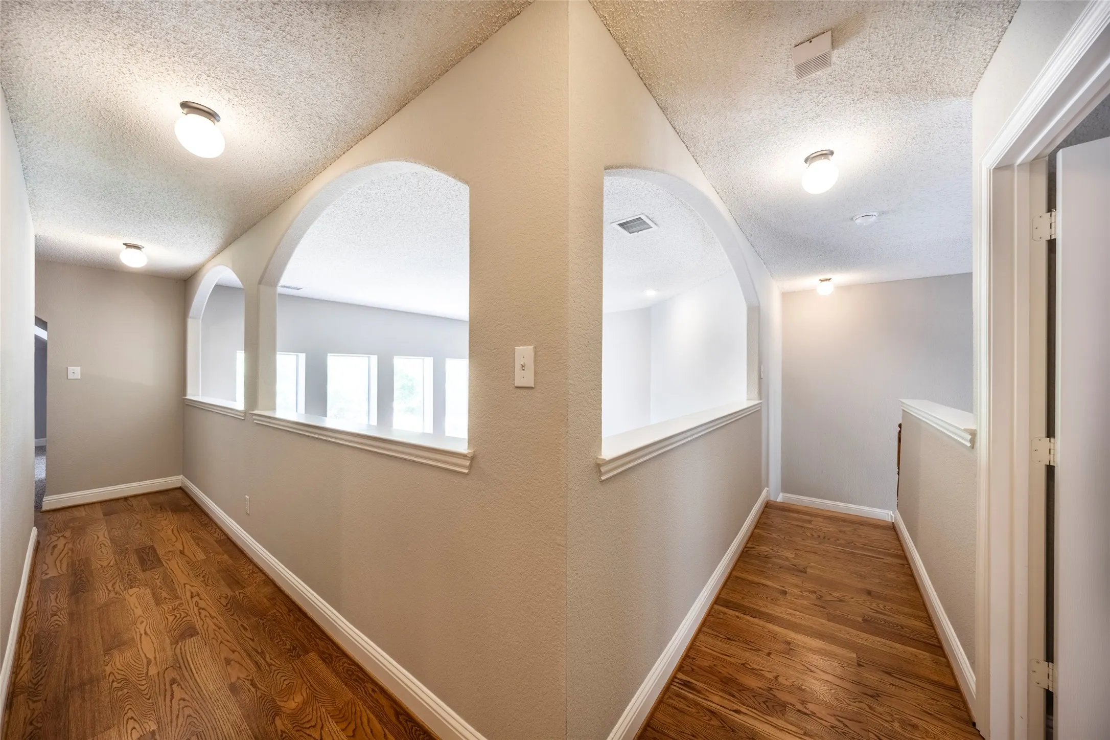 The property features hallways with wood flooring and light-colored walls