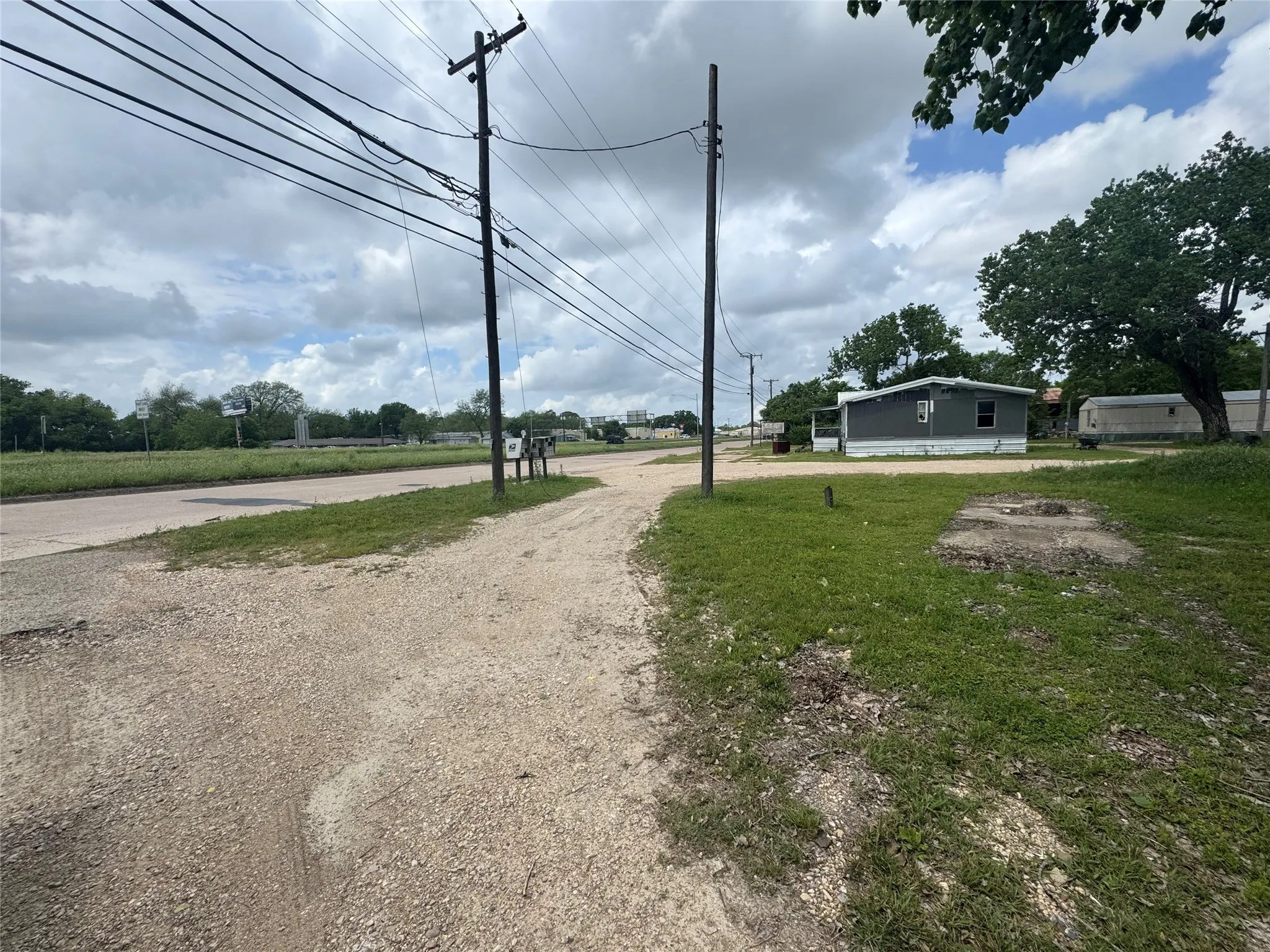 The property features an unpaved driveway and a grass lawn