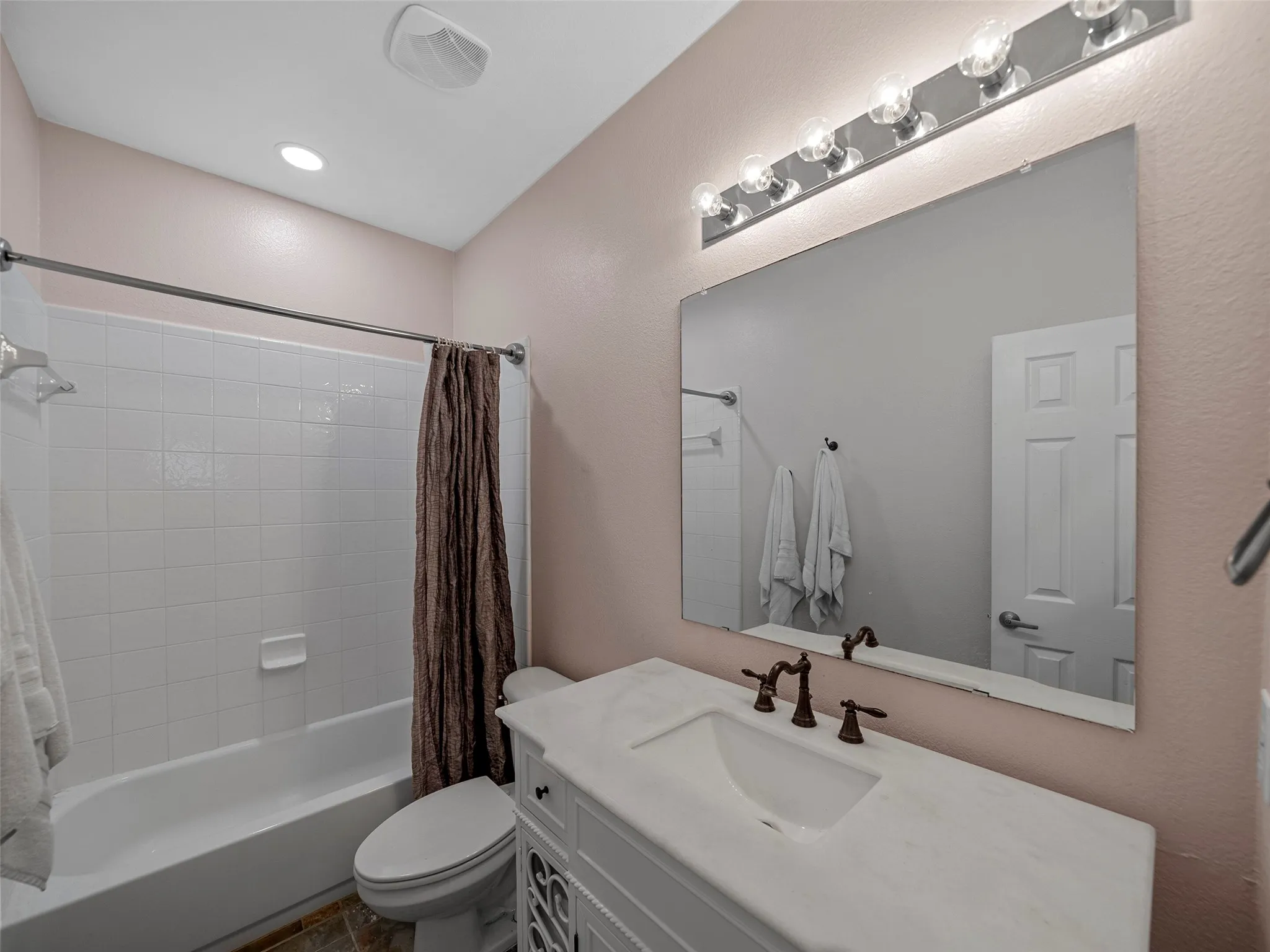 Full bath featuring vanity and shower / tub combo