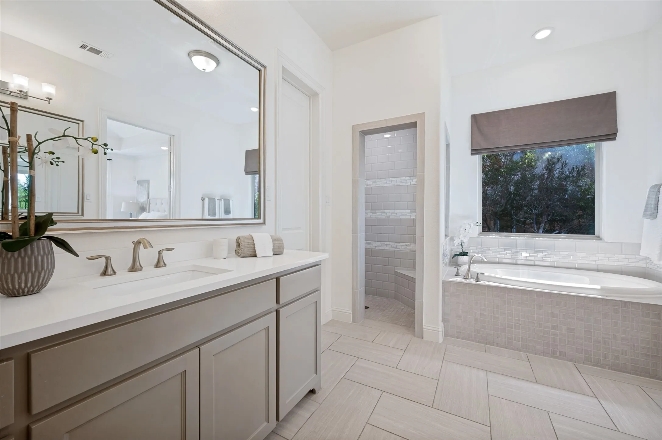 Dual vanity with a rectangular undermount sink, brushed nickel faucet, and a large framed mirror