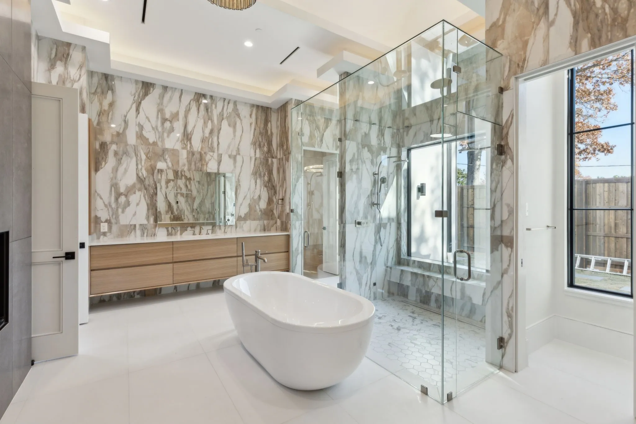 Bathroom with tile walls, vanity, a marble finish shower, a soaking tub, and tile patterned floors