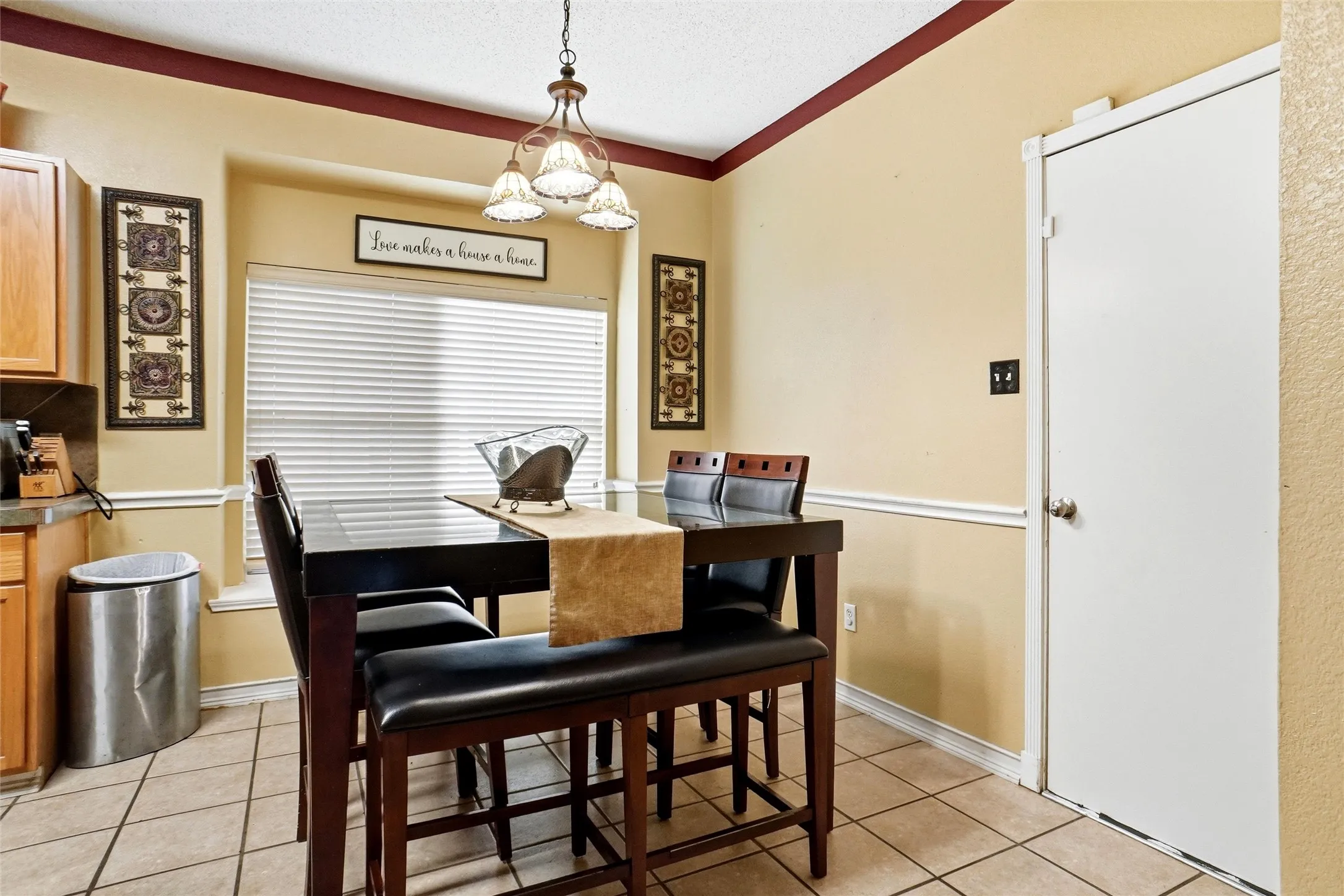 The dining area features a window with blinds, tile flooring, and a ceiling-mounted light fixture