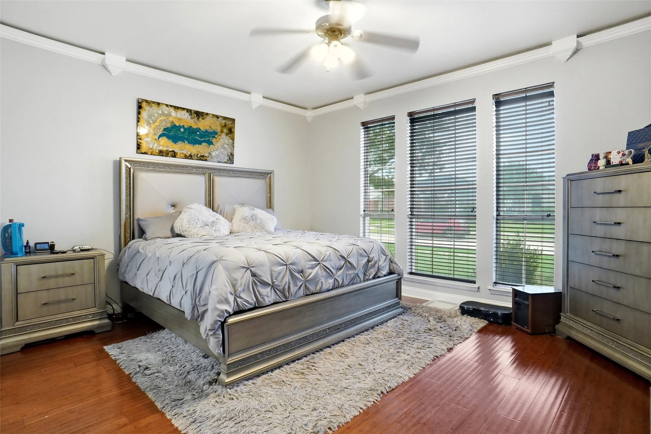 This room features hardwood flooring, white walls, and crown molding