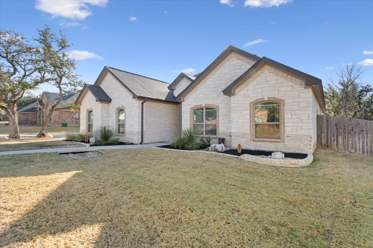 The property features an exterior of light-colored stone with dark trim and a dark roof