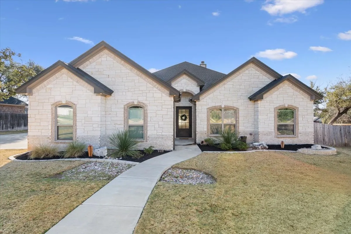 This property features a stone exterior and a well-maintained lawn