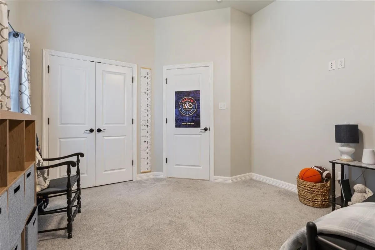 This room features light gray wall paint, light gray carpet, and white baseboards