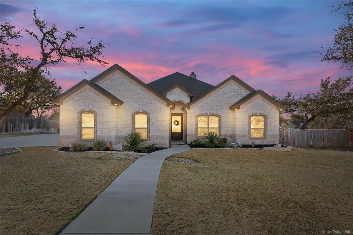 The property features a stone exterior, a dark roof, and a well-maintained lawn