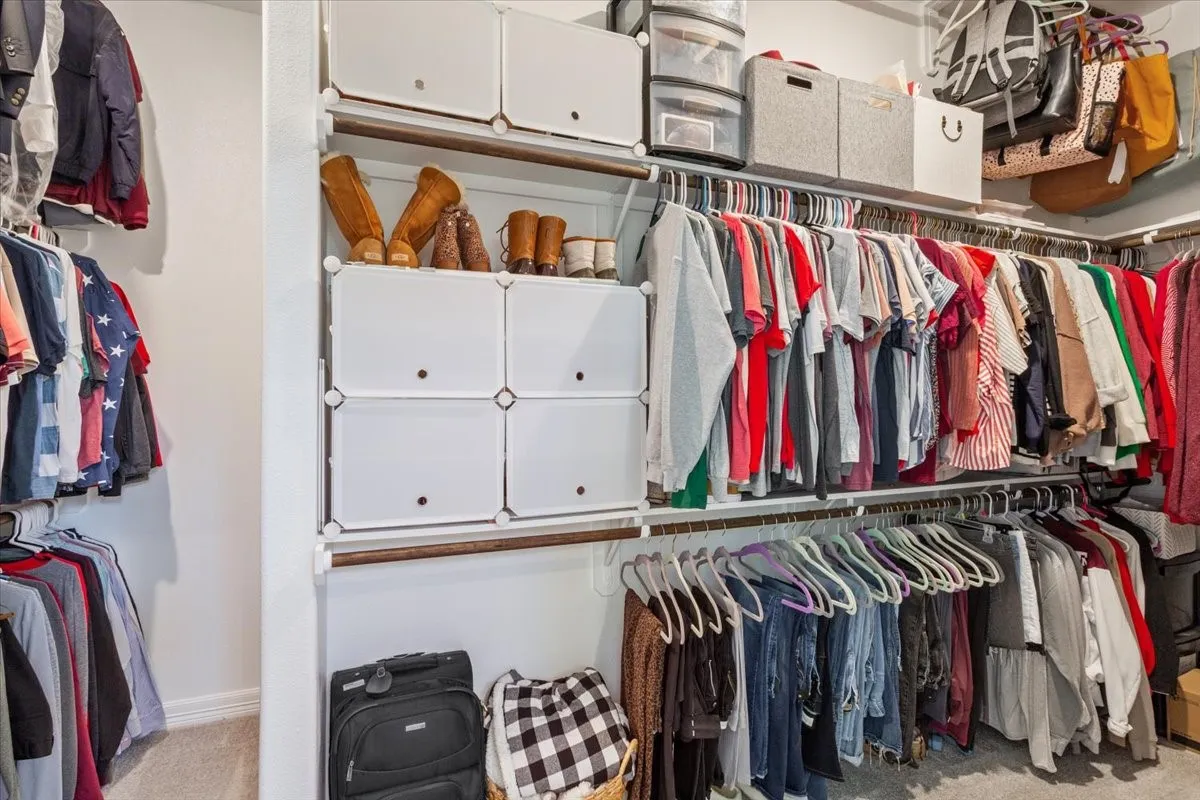 The property includes a spacious walk-in closet featuring built-in shelving, hanging rods, and modular storage units