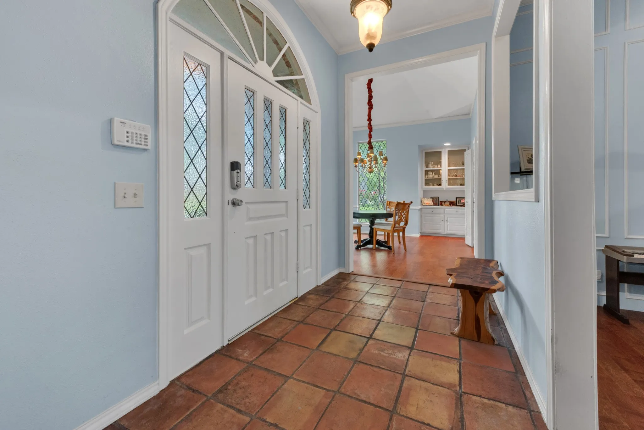 Entryway featuring terra cotta tile flooring and a double front door with leaded glass inserts