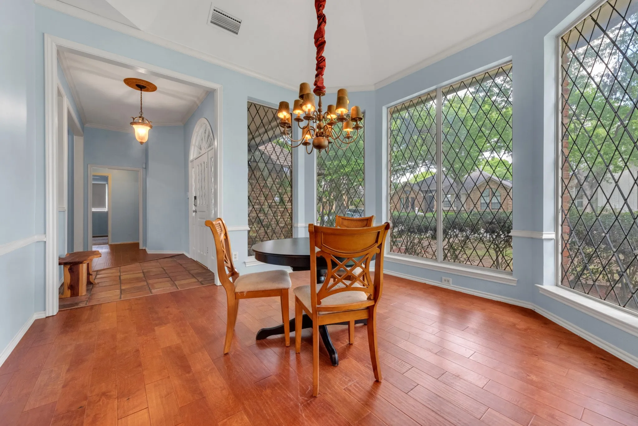 This dining area features hardwood floors, a domed ceiling, and a chandelier