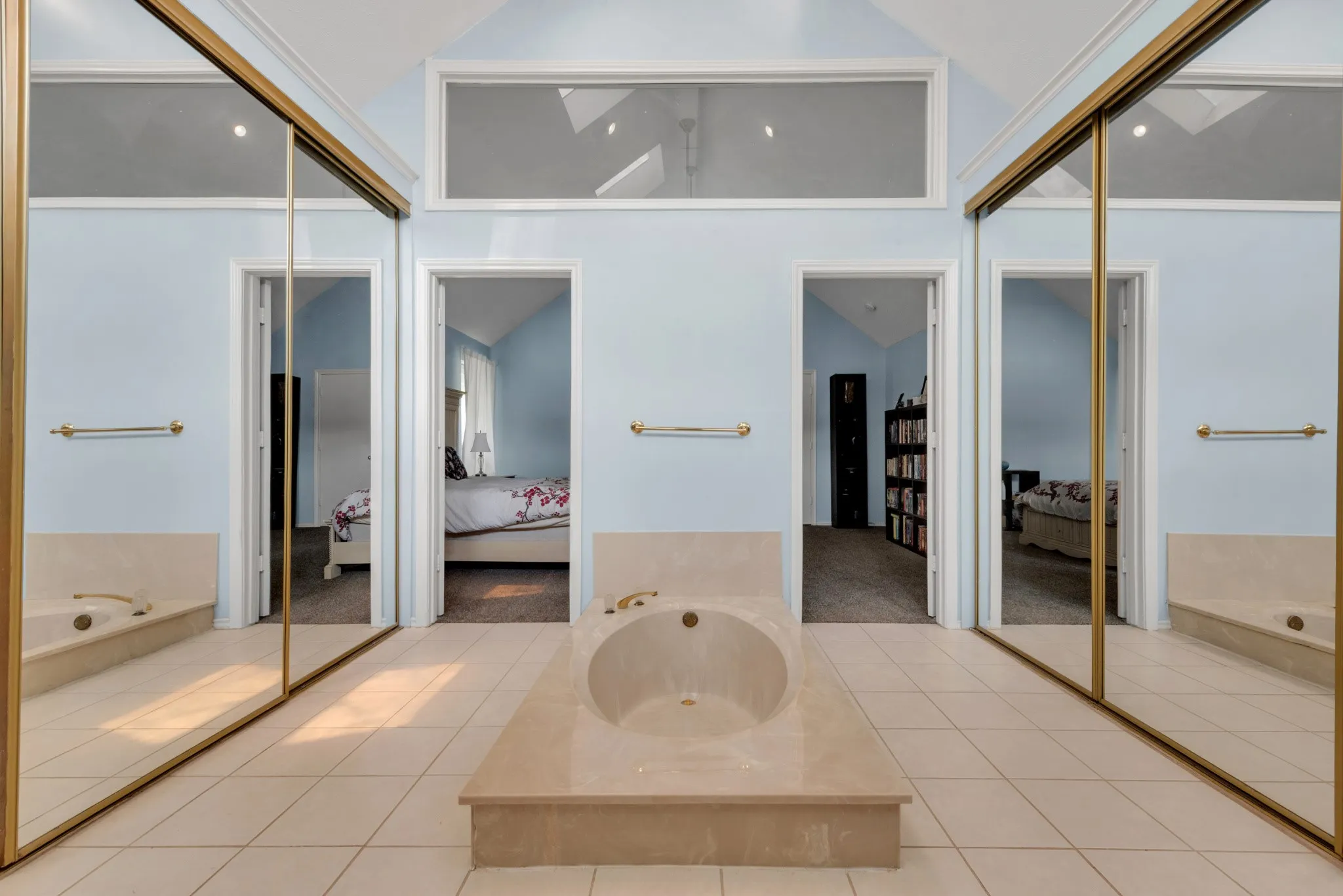 The bathroom features a built-in bathtub, light-colored tile flooring, and mirrored closet doors