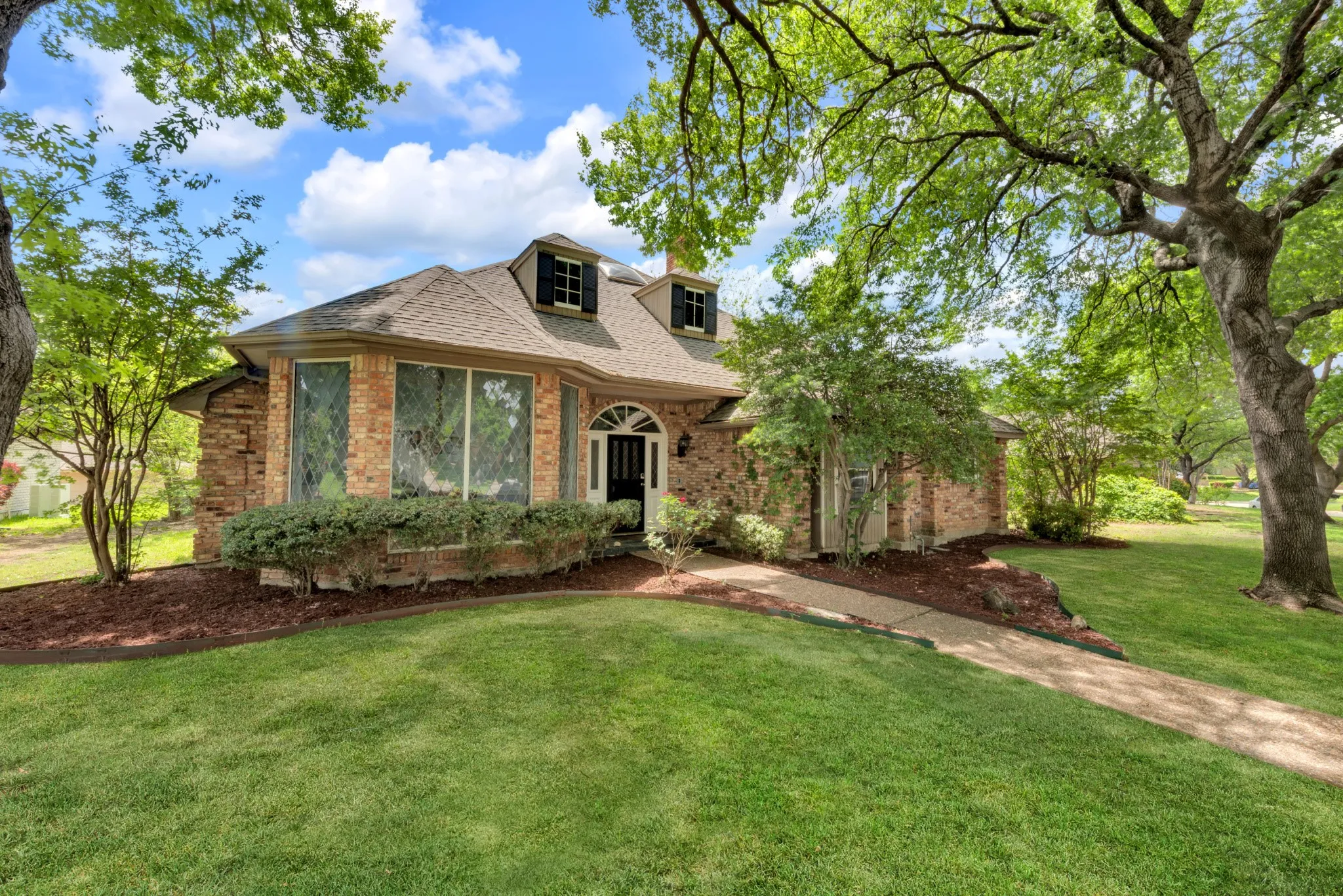 This property features a brick exterior with a traditional roof and dormer windows