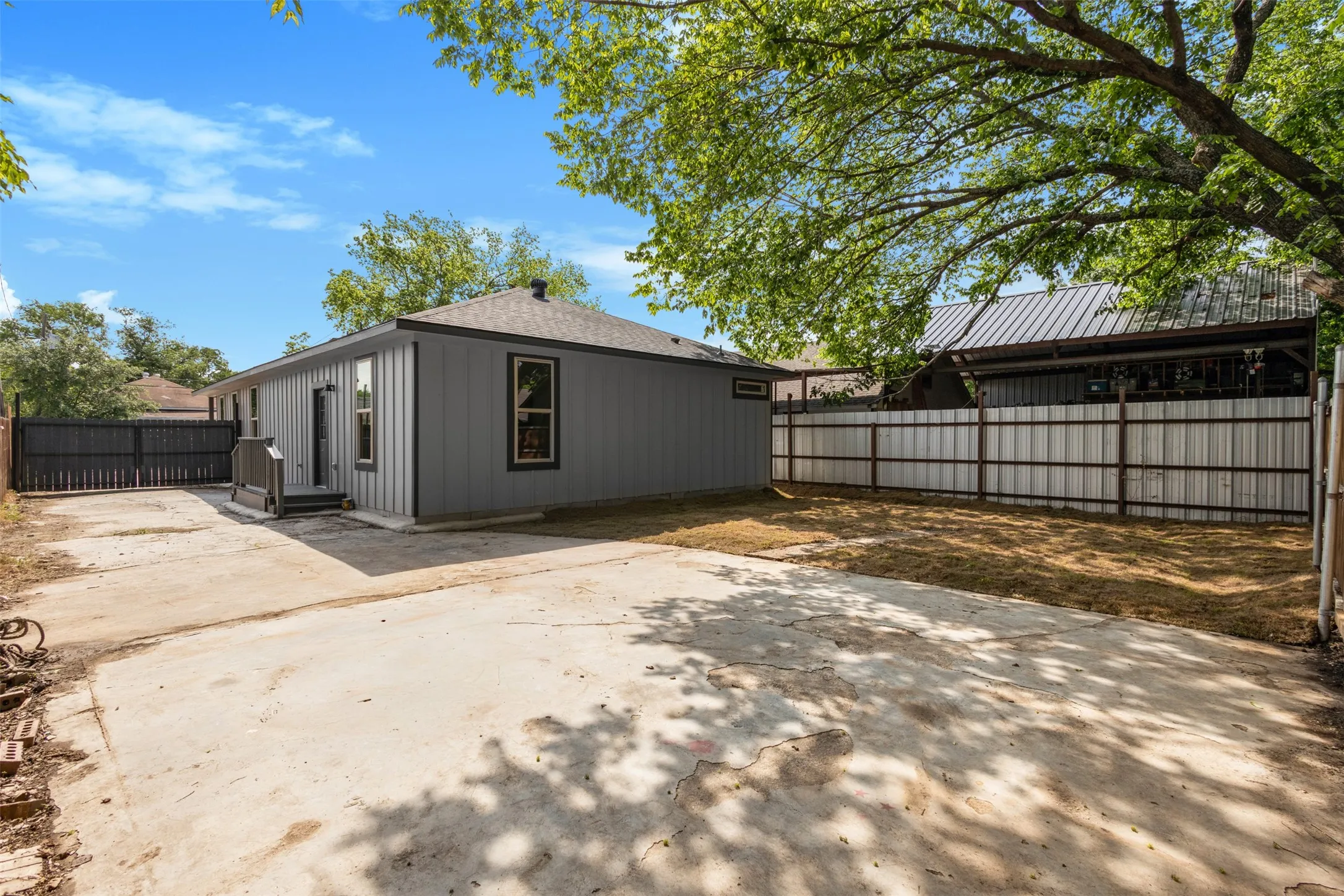 The property features a concrete driveway and a fenced yard with a combination of fencing styles