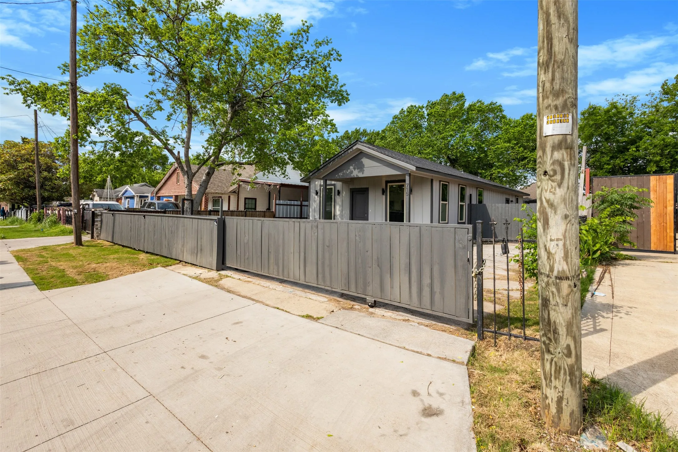 The property features a gated entrance with a wooden fence and a separate pedestrian gate
