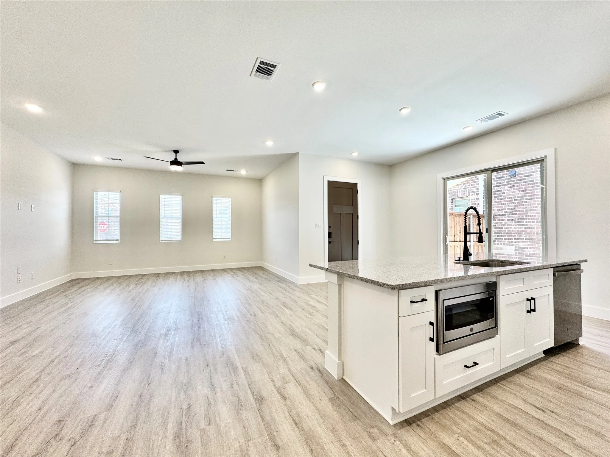 Kitchen with a sink, appliances with stainless steel finishes, plenty of natural light, baseboards, and recessed lighting