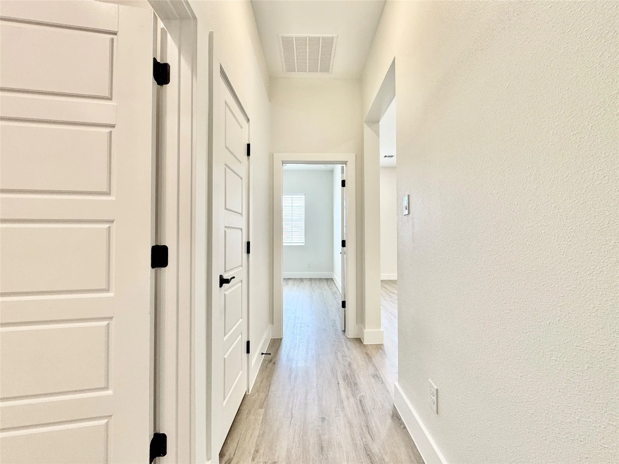 Corridor featuring light wood-style floors and baseboards