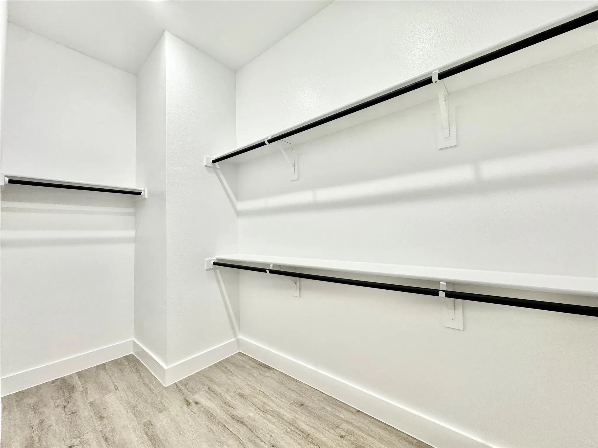 Walk in closet with light wood-style flooring