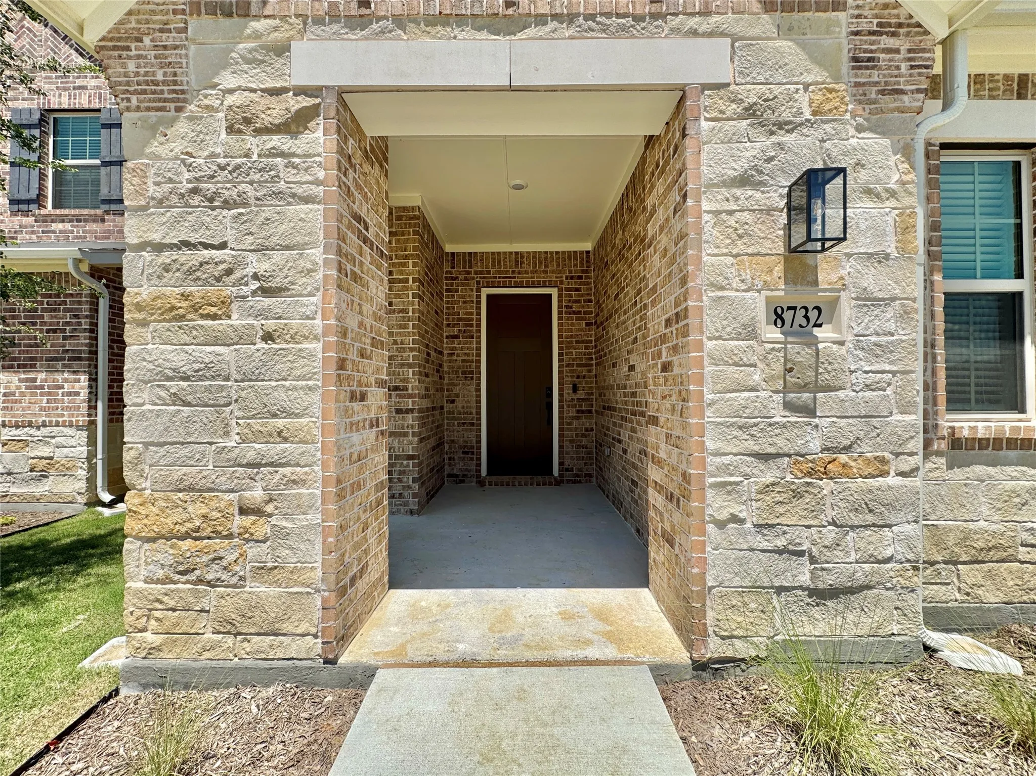 View of exterior entry with brick siding and stone siding