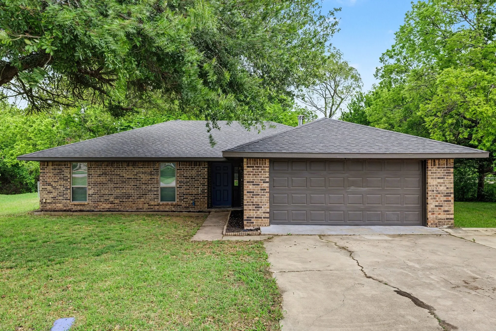 Classic brick exterior with dark roof and attached two-car garage