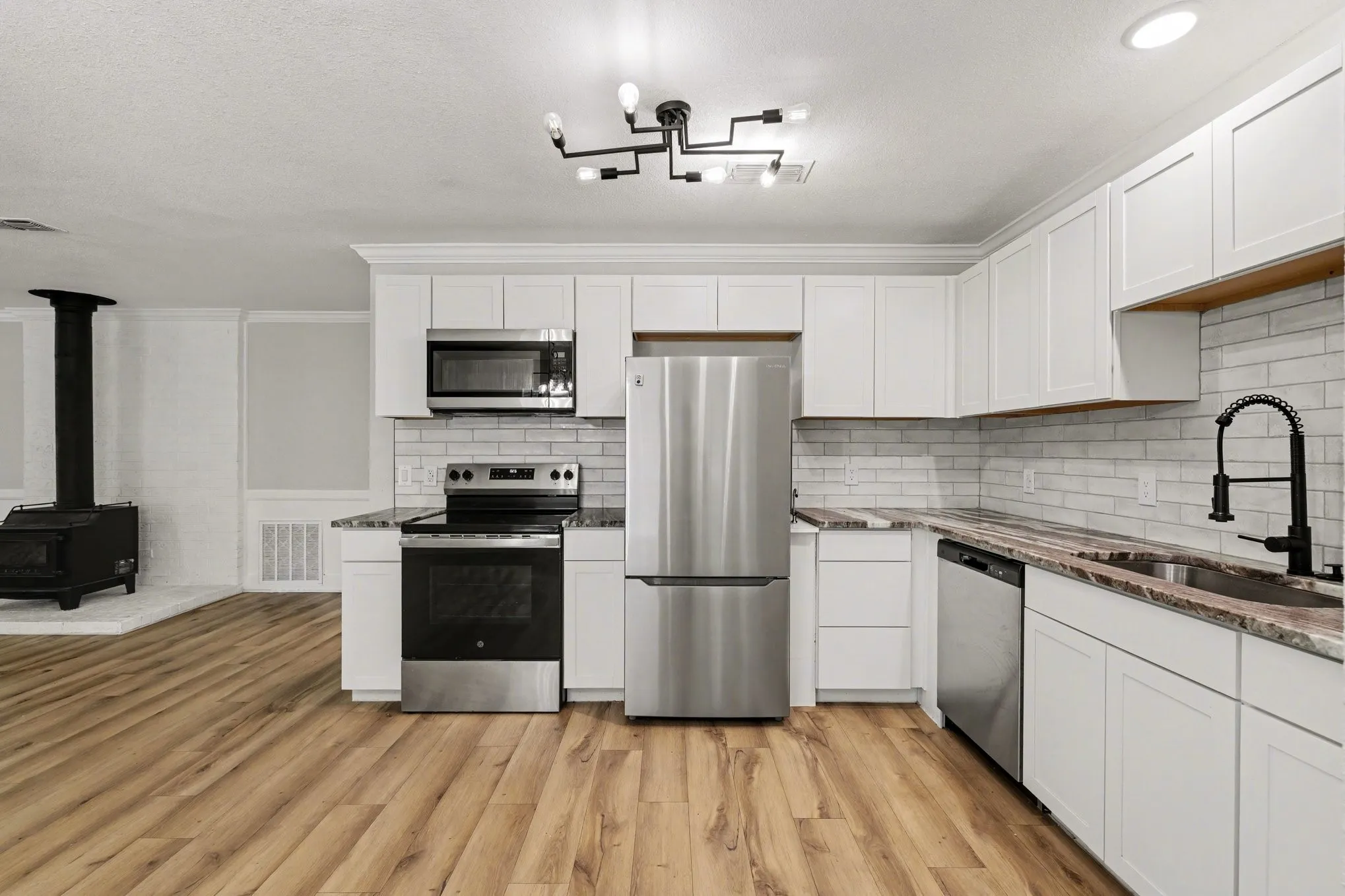 Kitchen includes shaker cabinets, granite-look counters, subway tile backsplash