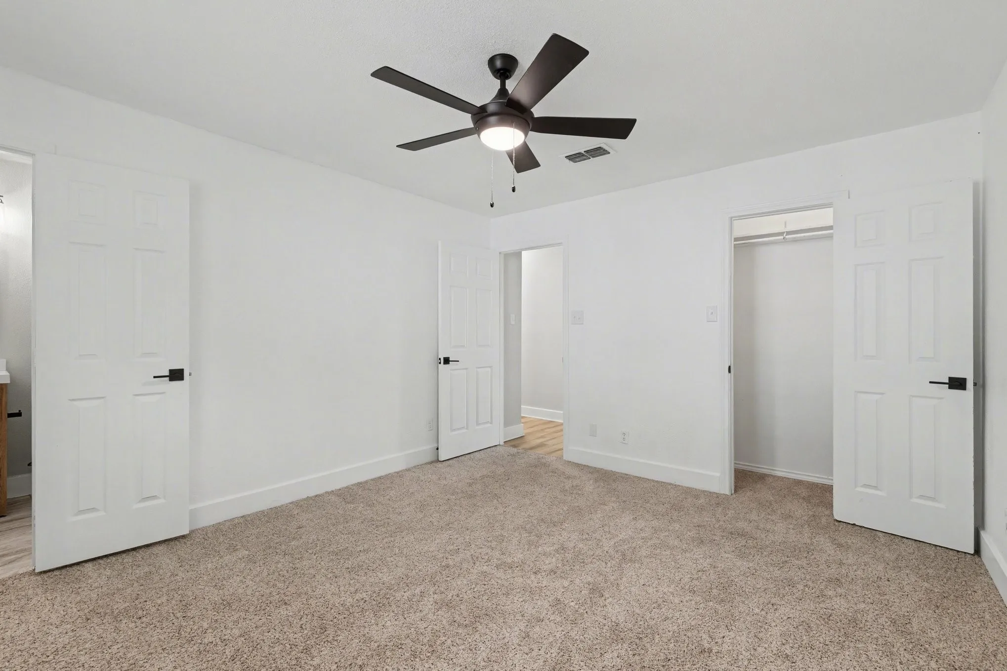 Bedroom with carpet, ceiling fan with light, and white walls