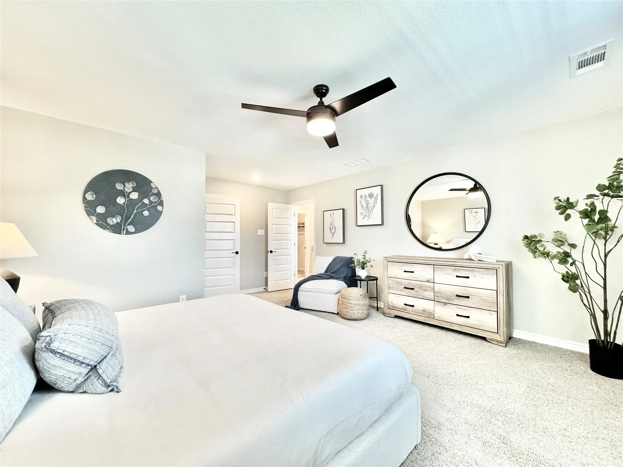 Carpeted bedroom with baseboards, visible vents, and a ceiling fan