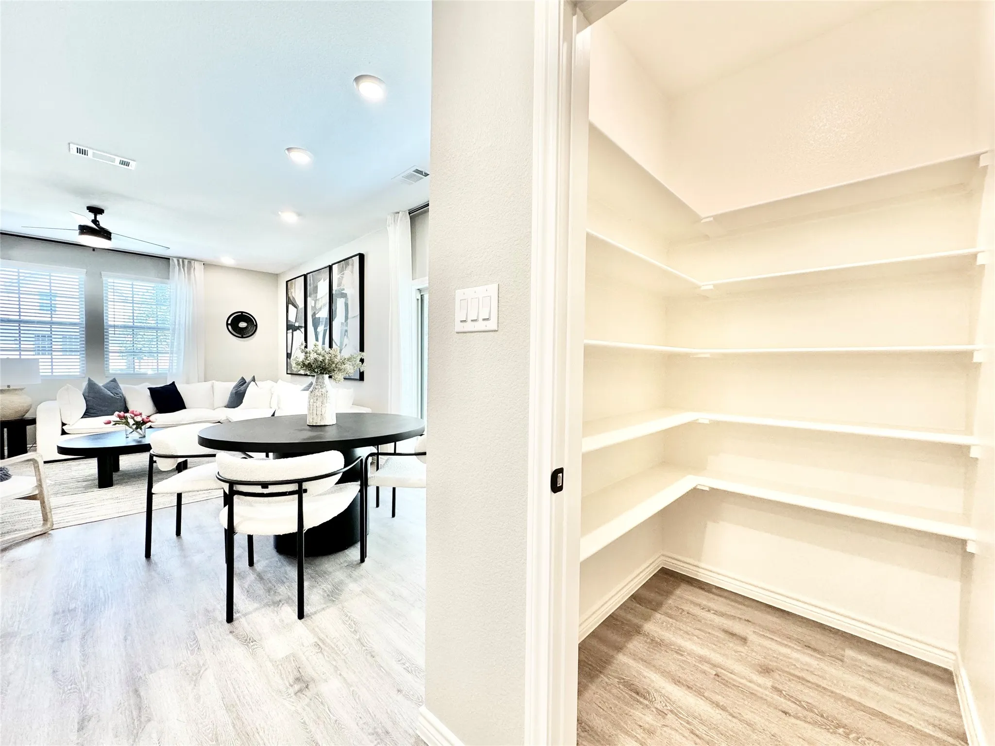 Unfurnished dining area with wood finished floors, a ceiling fan, breakfast area, visible vents, and baseboards
