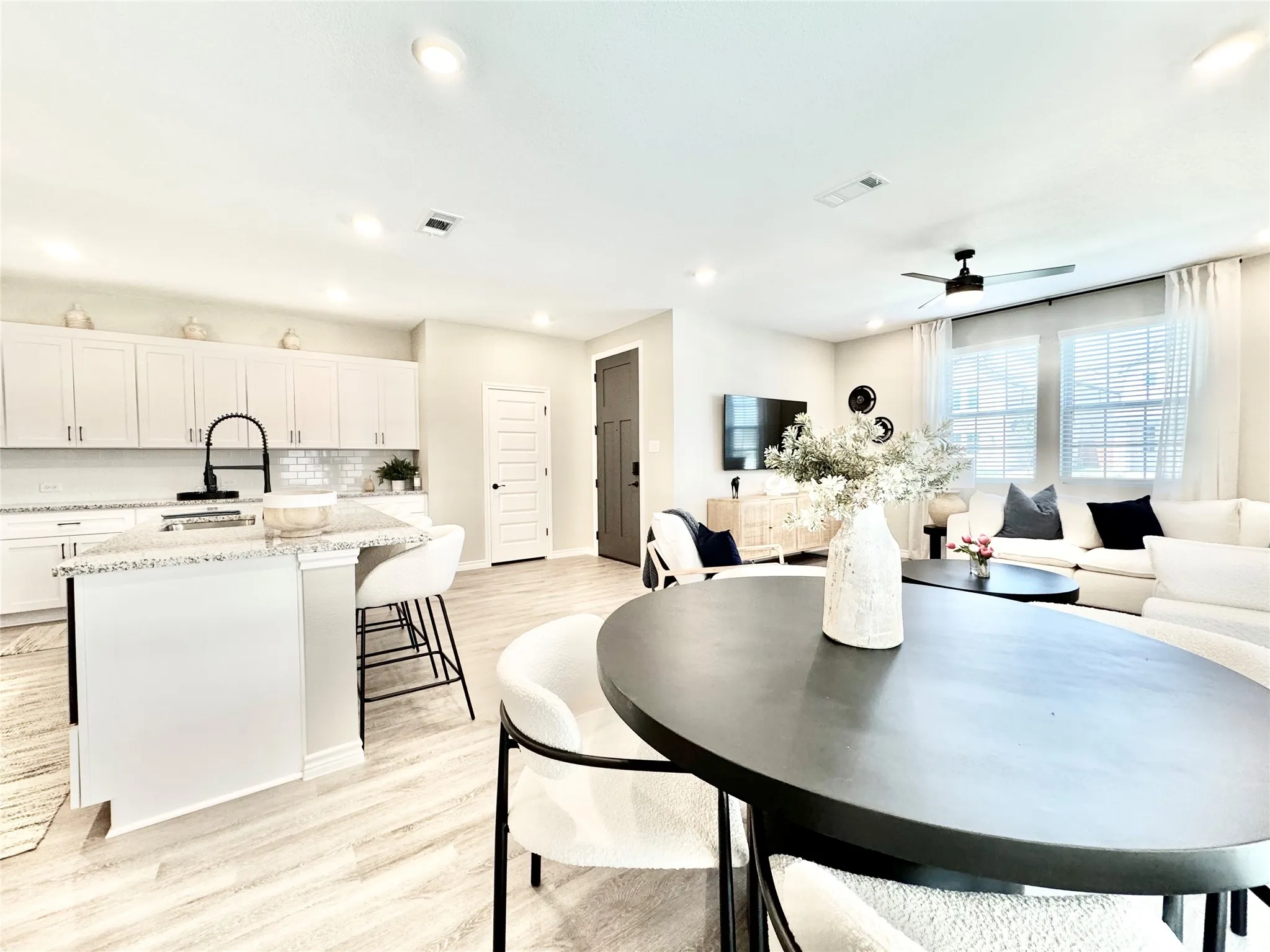 Dining room featuring light wood-style flooring, a ceiling fan, visible vents, and recessed lighting
