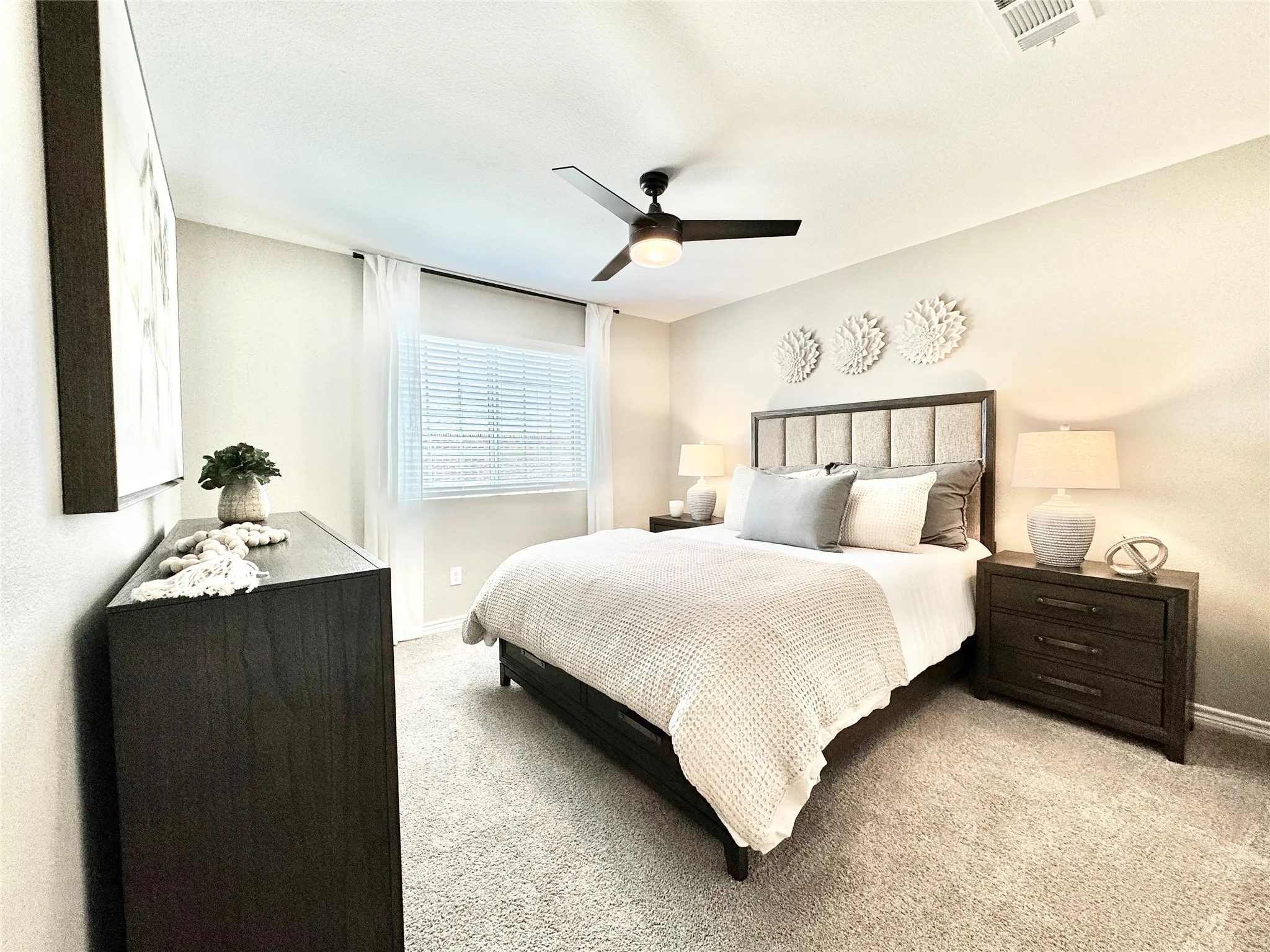 Bedroom featuring light colored carpet, baseboards, a ceiling fan, and visible vents