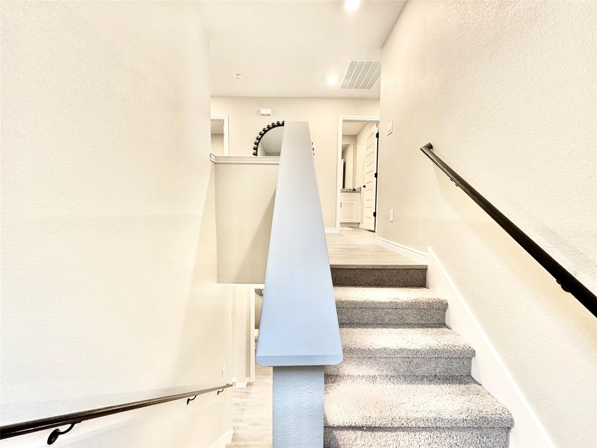 Stairway with wood finished floors, visible vents, baseboards, and recessed lighting