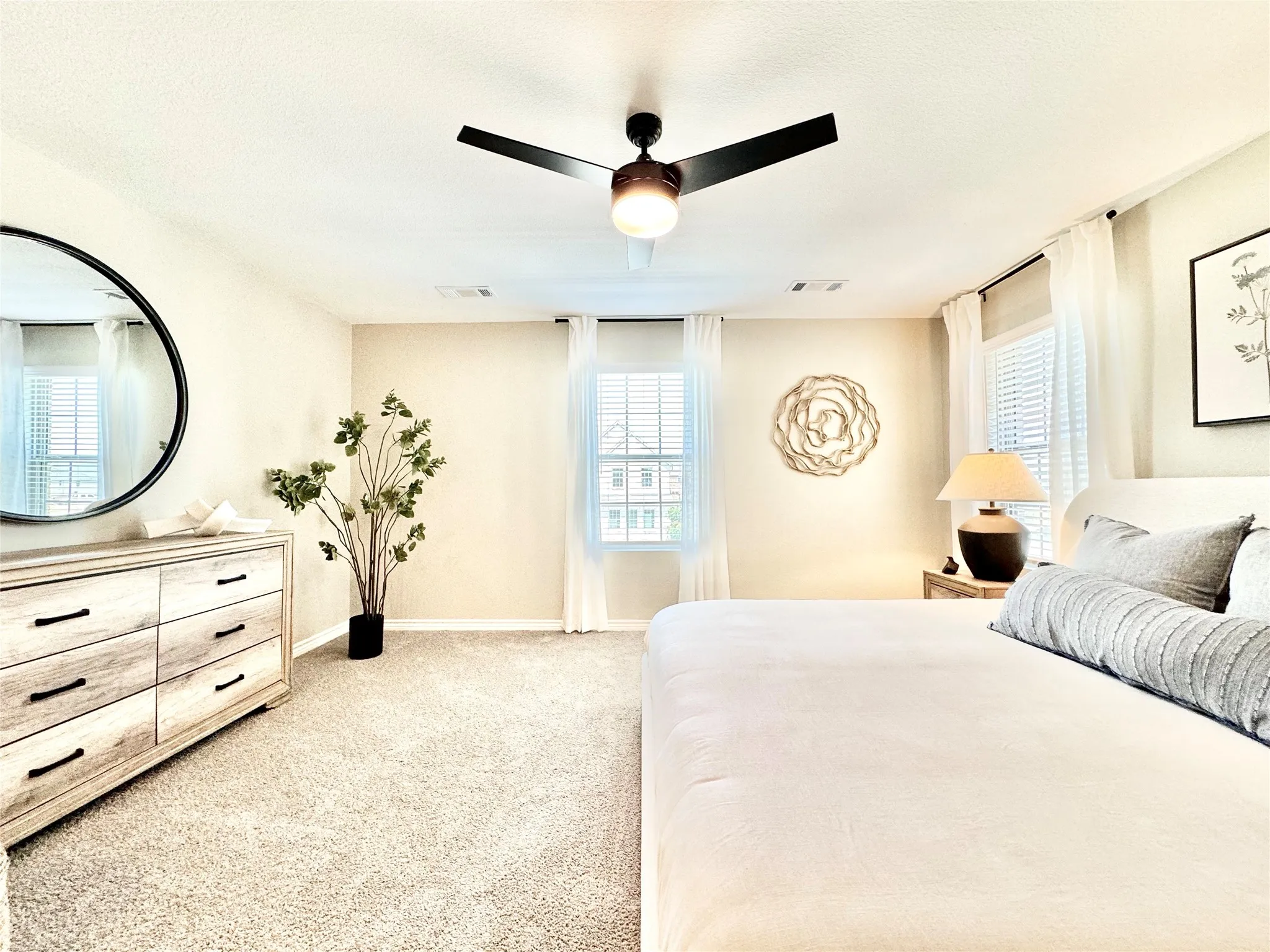 Bedroom featuring multiple windows, light carpet, and visible vents