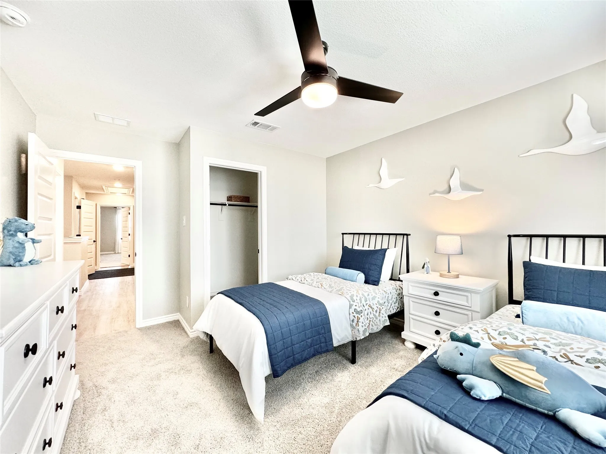Bedroom with a closet, light colored carpet, visible vents, ceiling fan, and baseboards