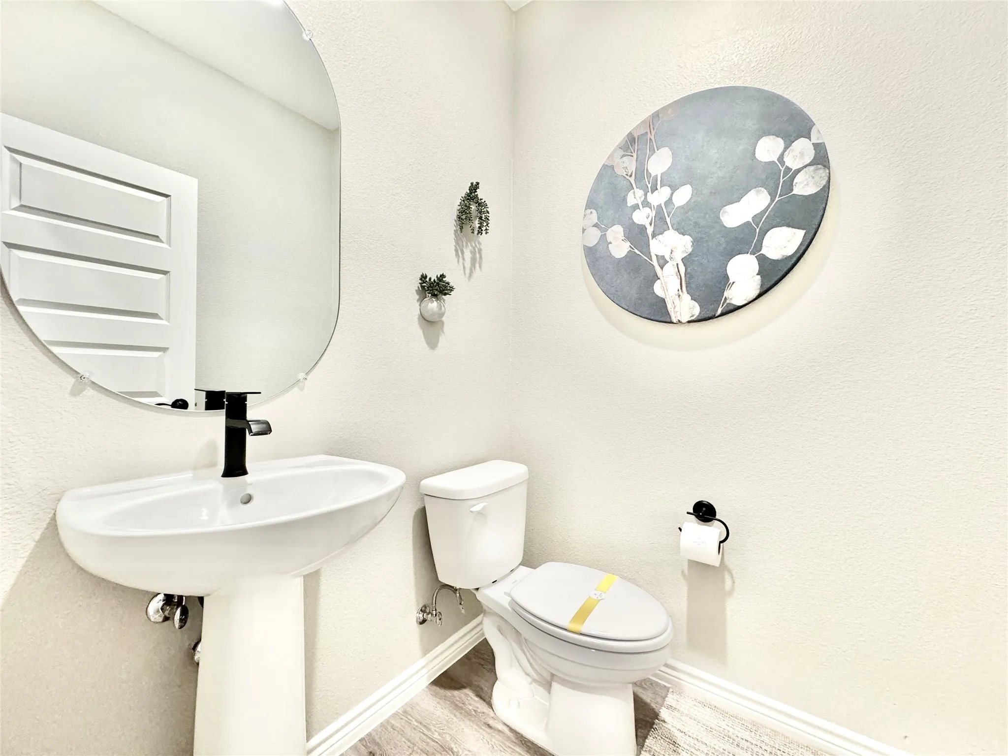 Bathroom featuring toilet, baseboards, and wood finished floors