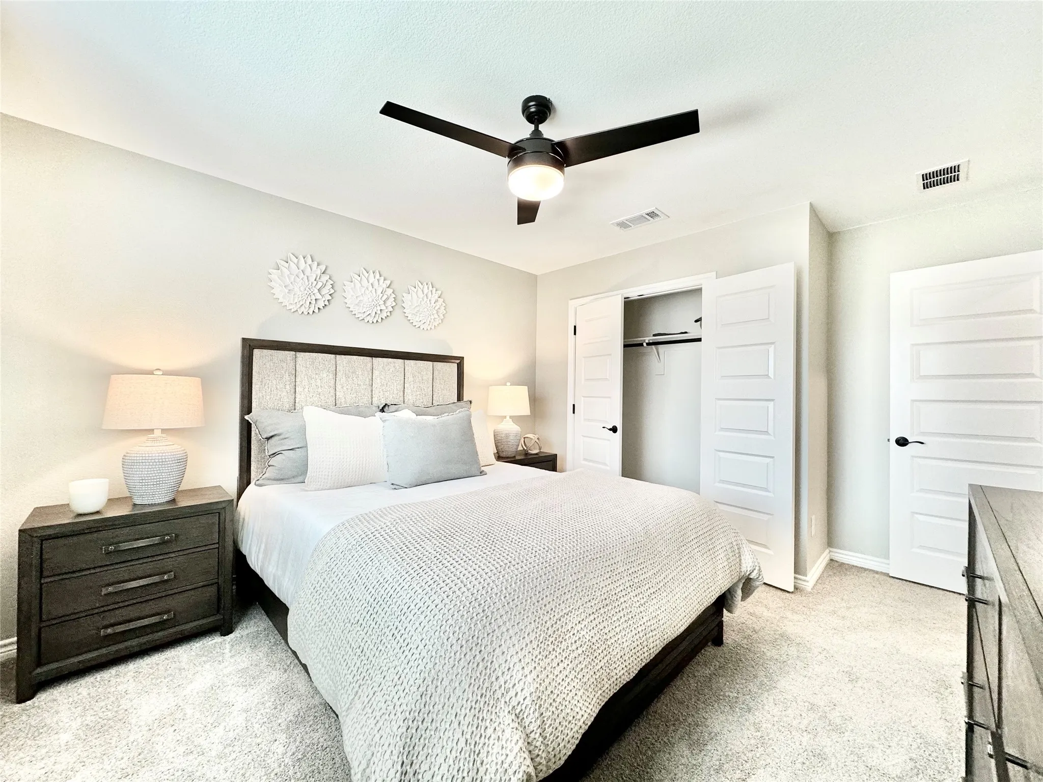 Bedroom with a closet, visible vents, baseboards, and light carpet