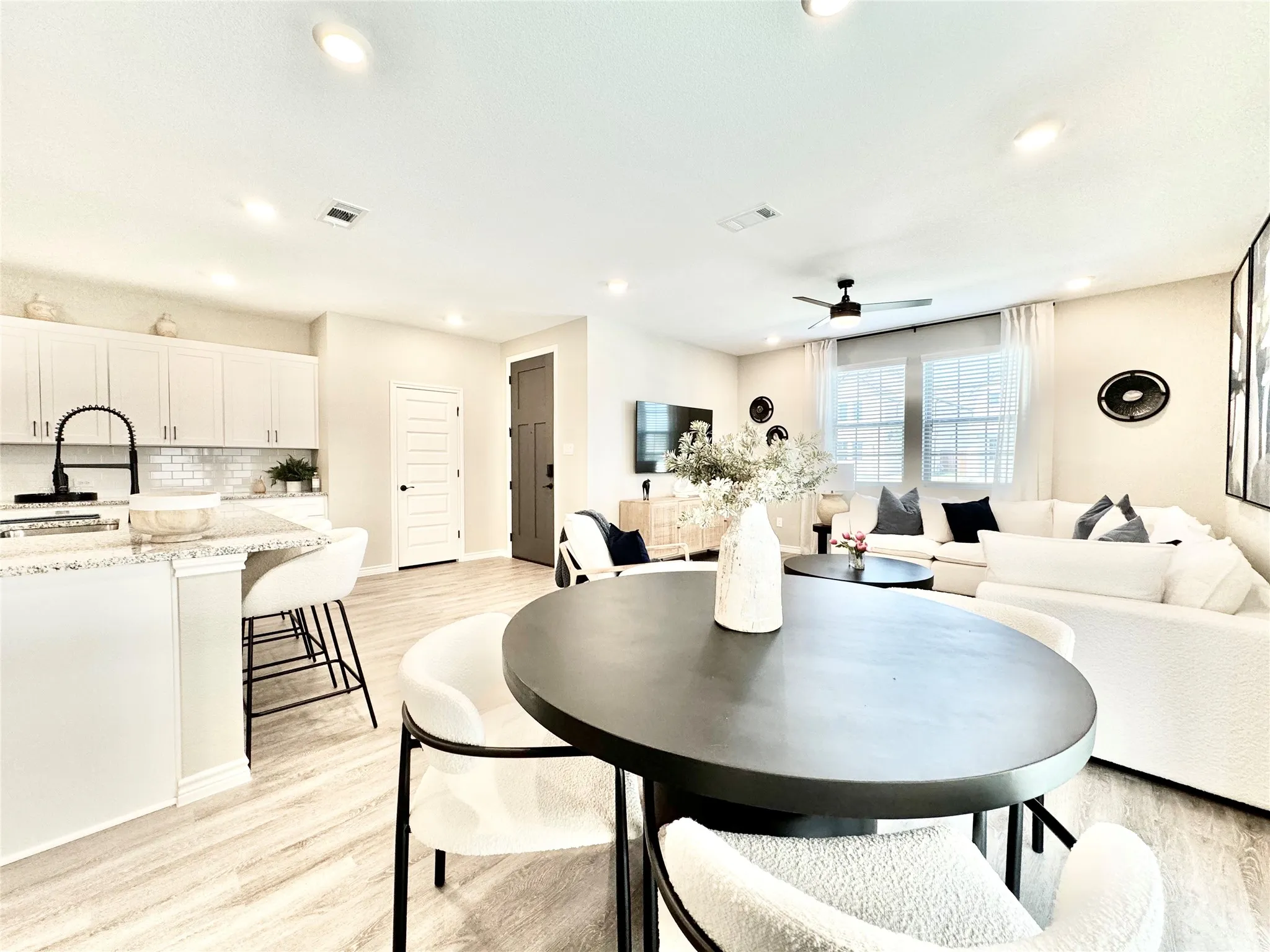 Dining space with light wood-style flooring, a ceiling fan, visible vents, and recessed lighting