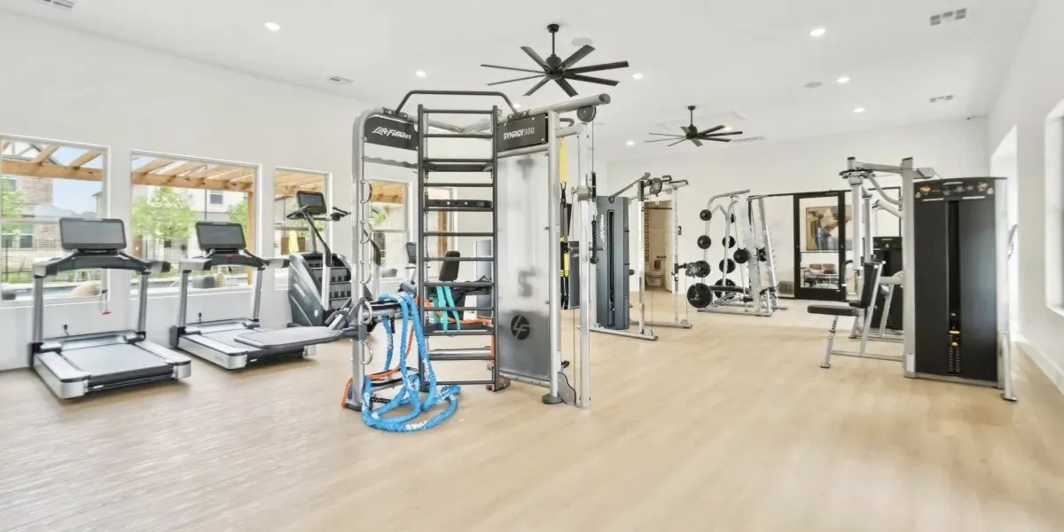 Gym featuring wood finished floors, ceiling fan, and recessed lighting