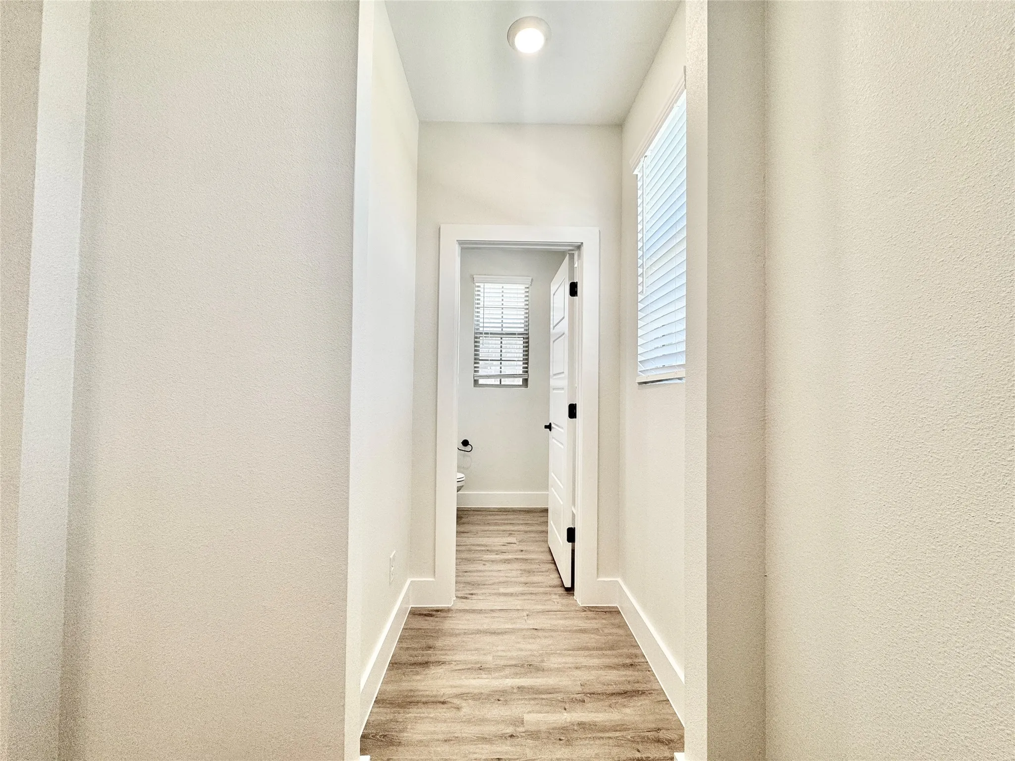 Corridor featuring light wood-style floors and baseboards