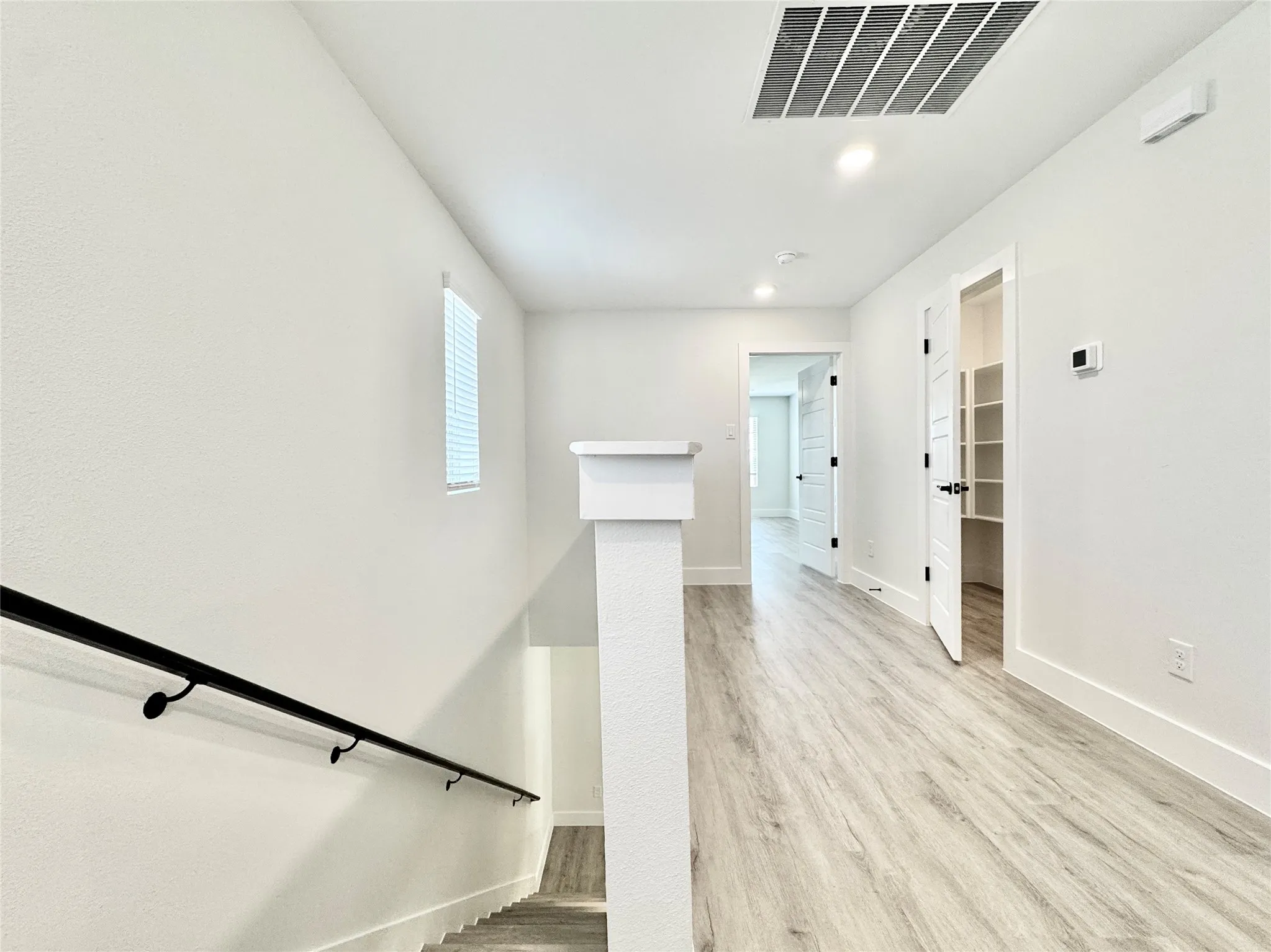 Stairs with baseboards, wood finished floors, and recessed lighting