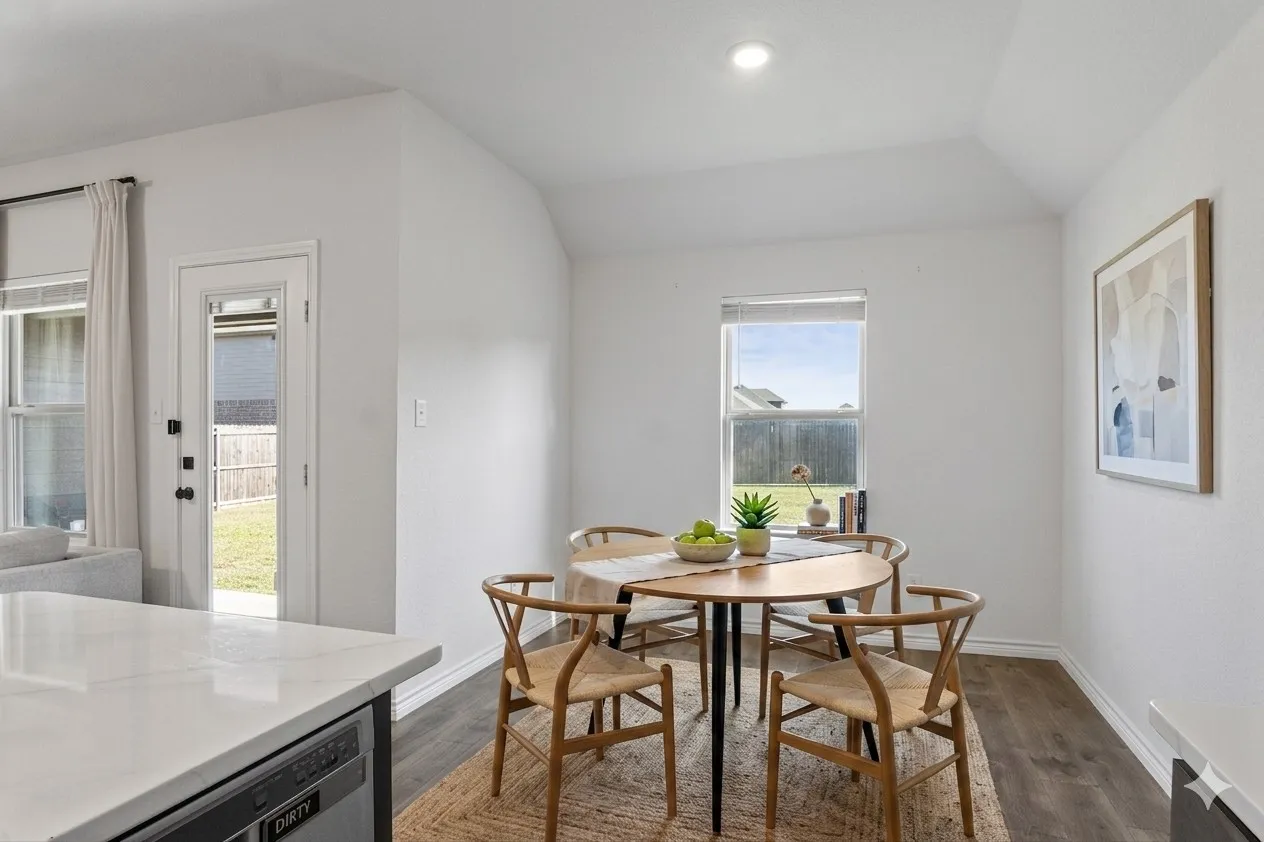 This bright dining area features a large window providing natural light, a modern light fixture, and wood-look flooring
