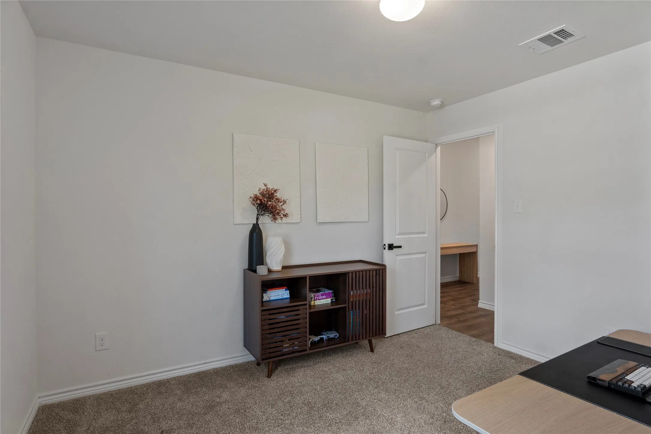 This room features light-colored walls and soft carpet flooring, providing a neutral canvas
