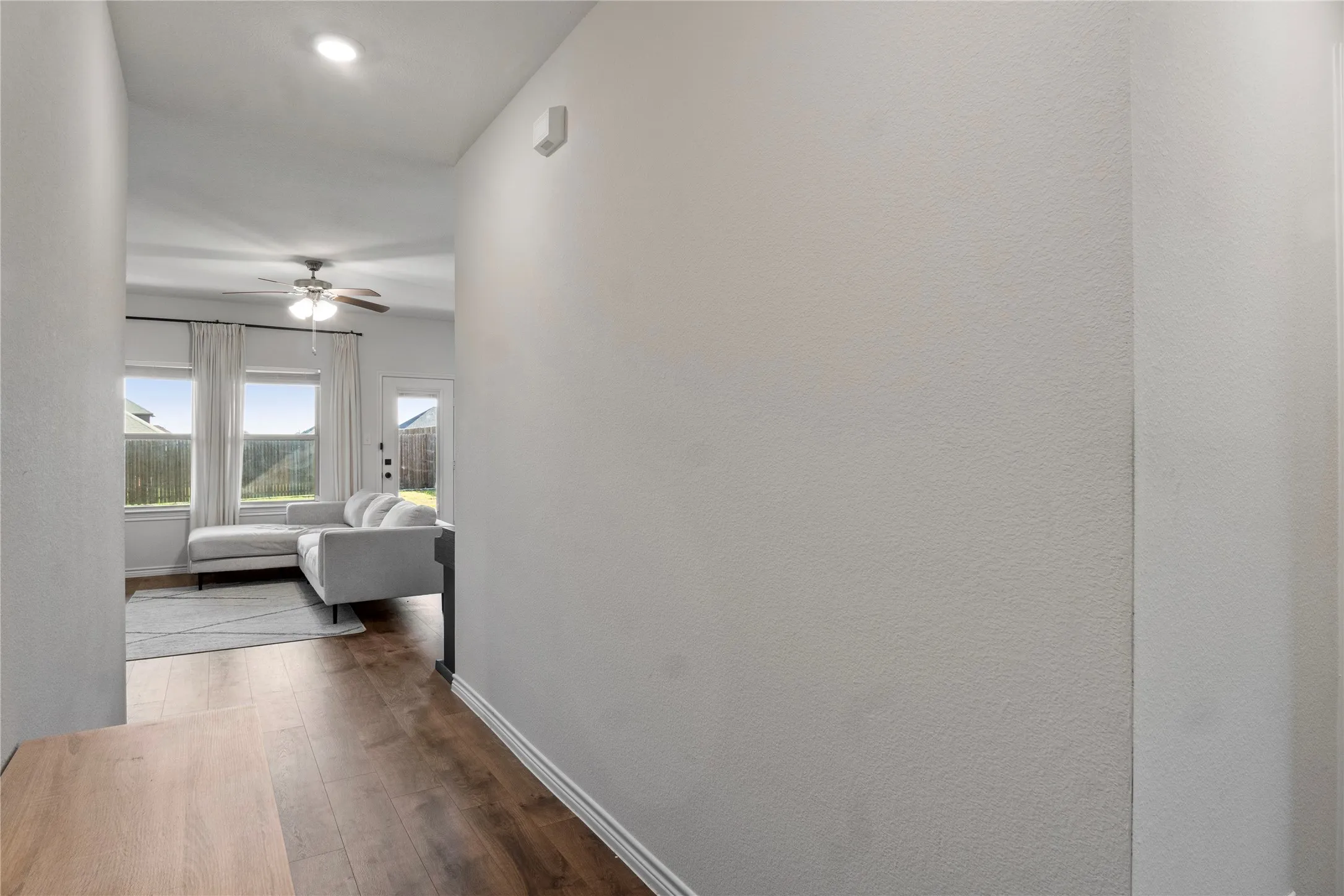 The property features light-colored walls and dark wood-style flooring in the hallway