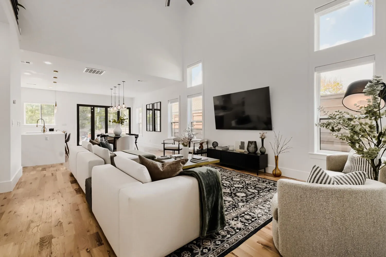 Living area with light wood-style flooring and a high ceiling