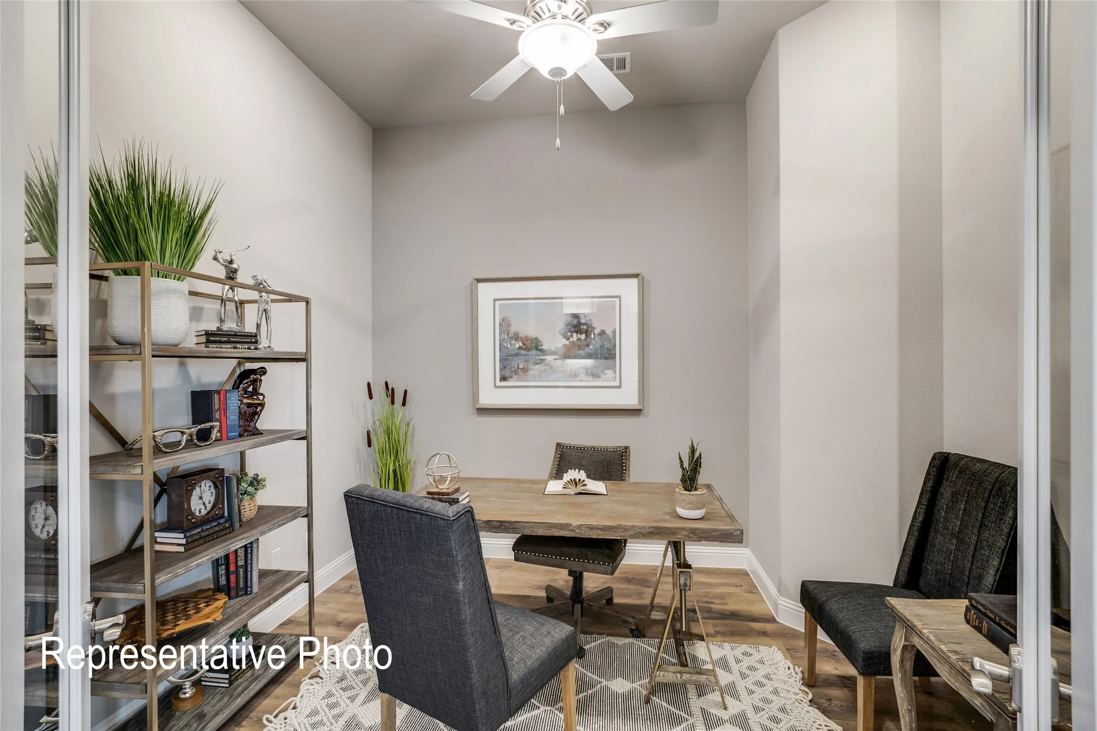 This versatile room features light-toned walls, a ceiling fan, and wood-look flooring