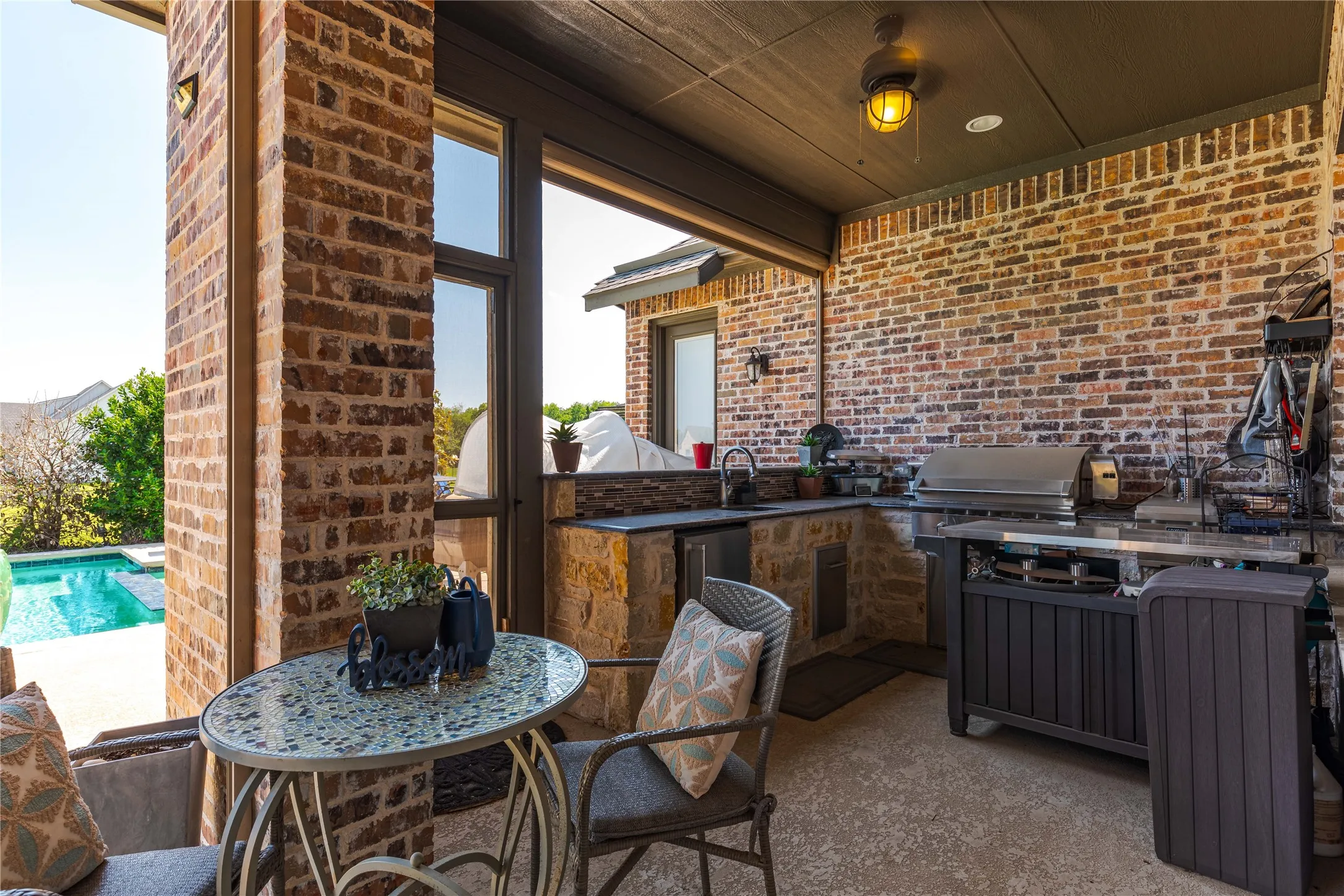 View of patio with outdoor wet bar, an outdoor pool, a sink, grilling area, and area for grilling