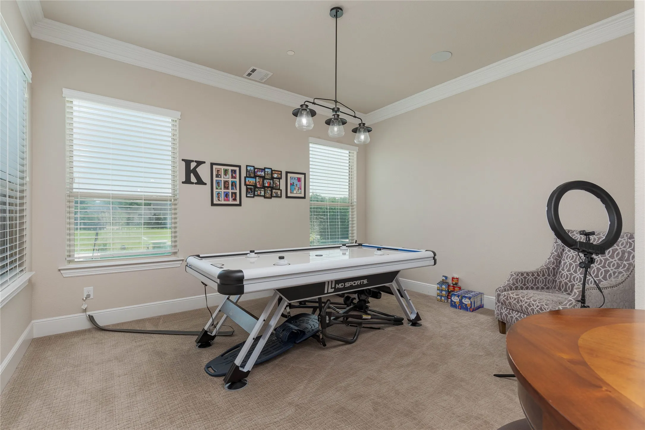 Playroom with light carpet, crown molding, visible vents, and baseboards
