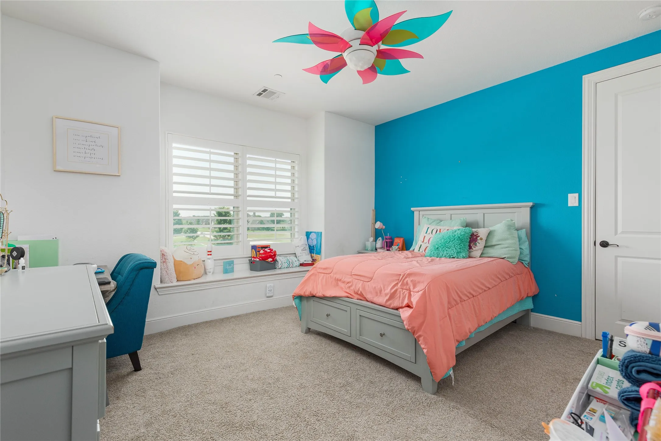 Carpeted bedroom with baseboards, visible vents, and ceiling fan