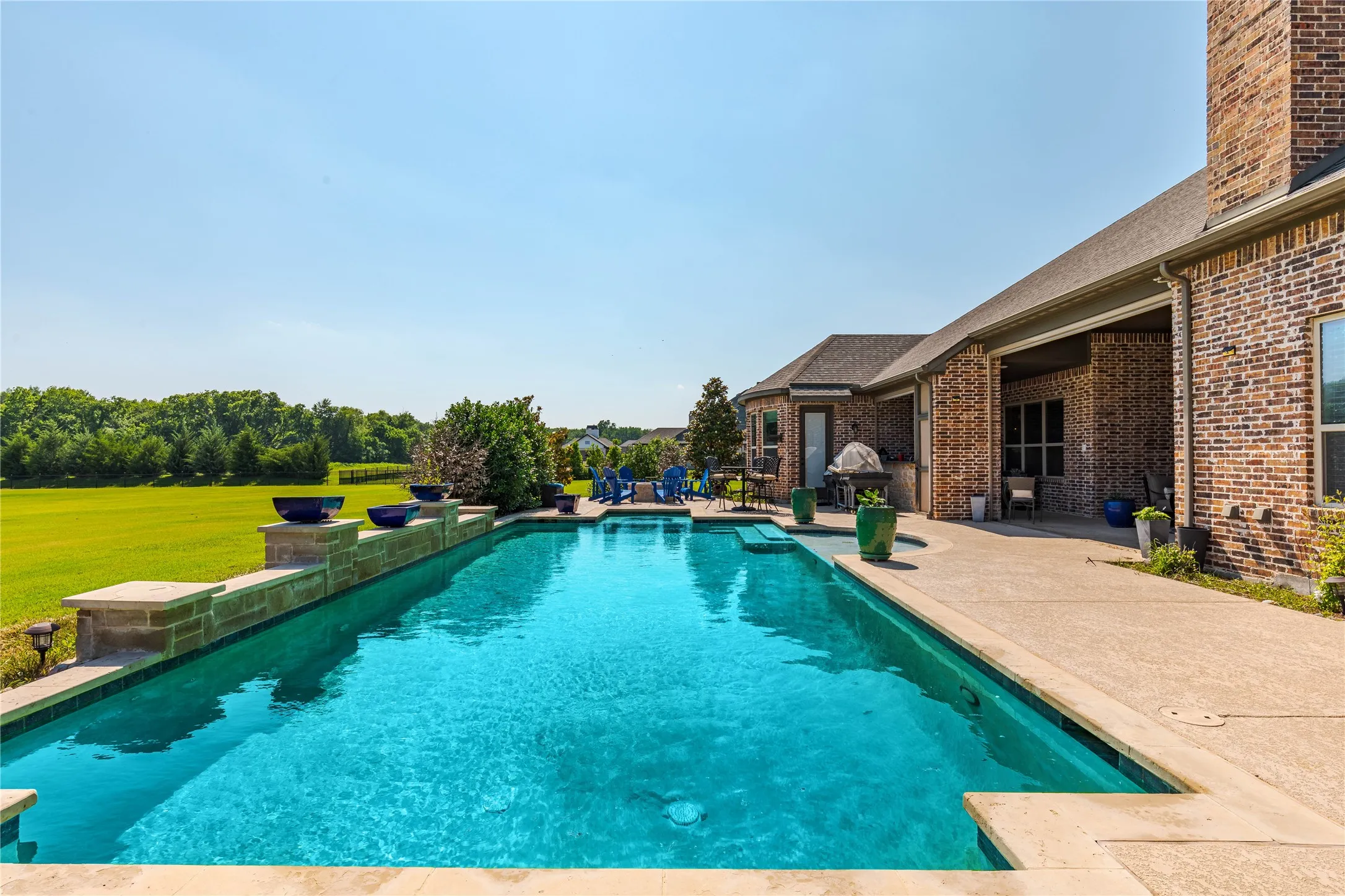 Outdoor pool featuring a yard and a patio area